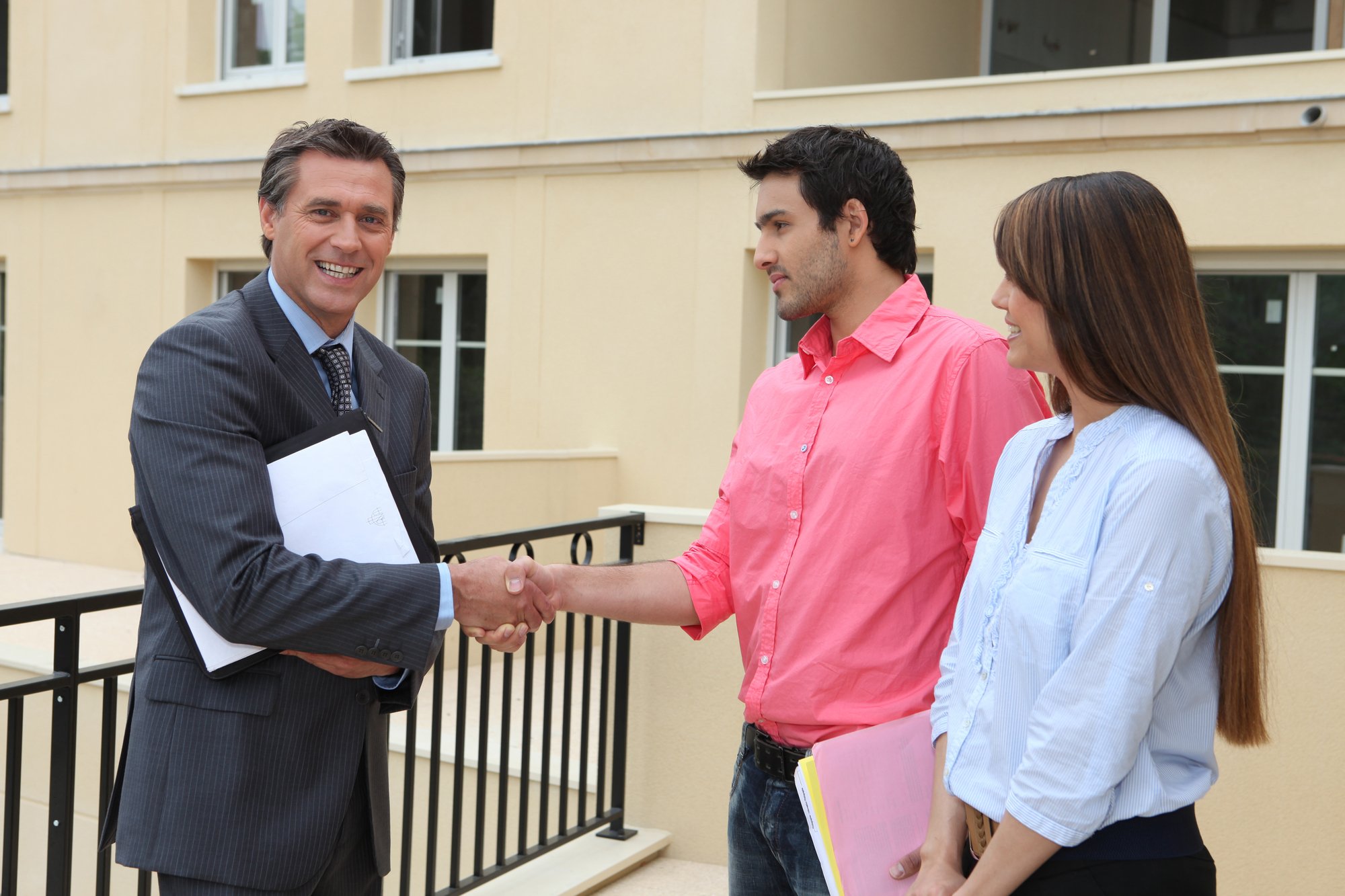 Couple shaking the hand of a real estate agent