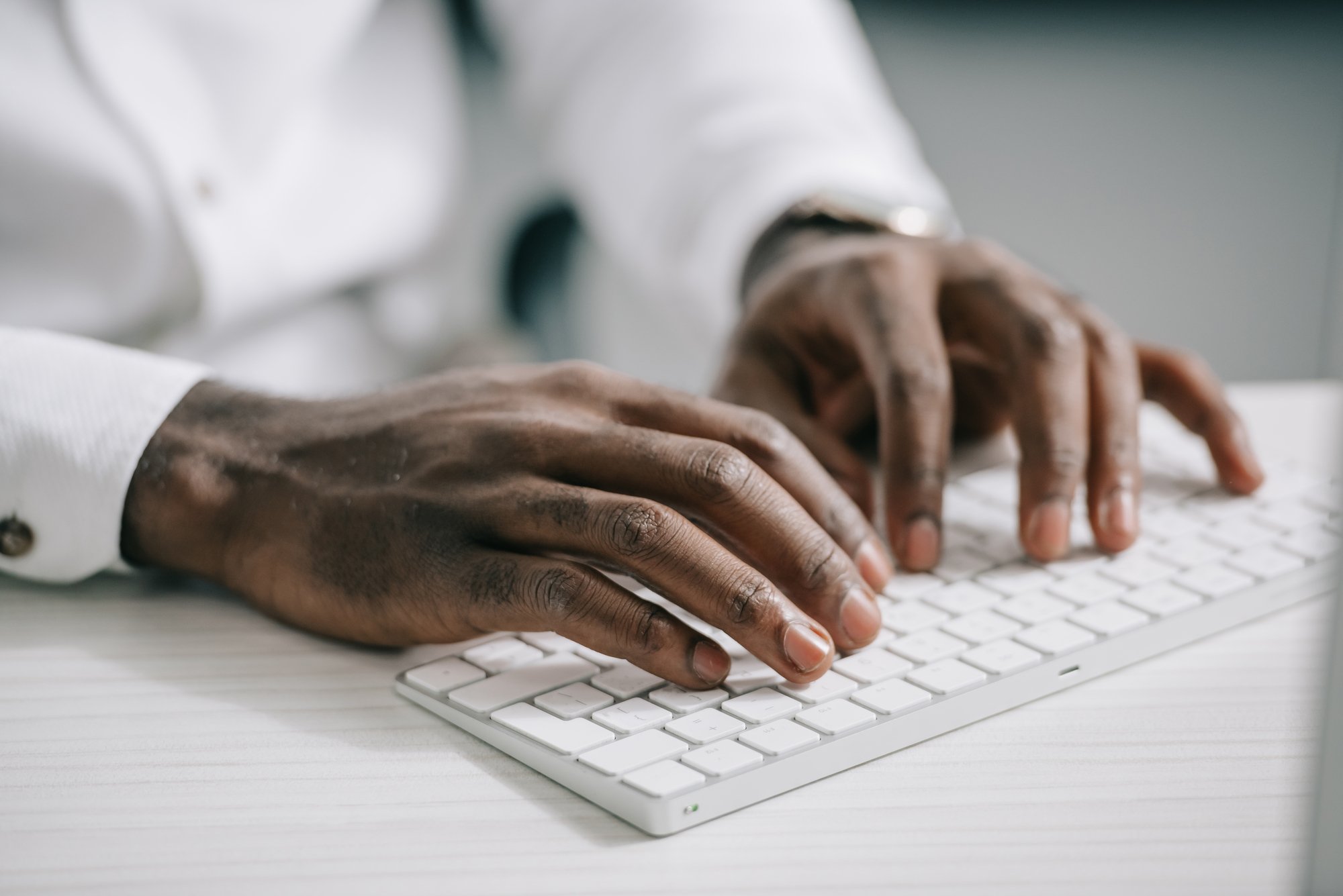 Cropped image of african american businessman typing on computer keyboard in office