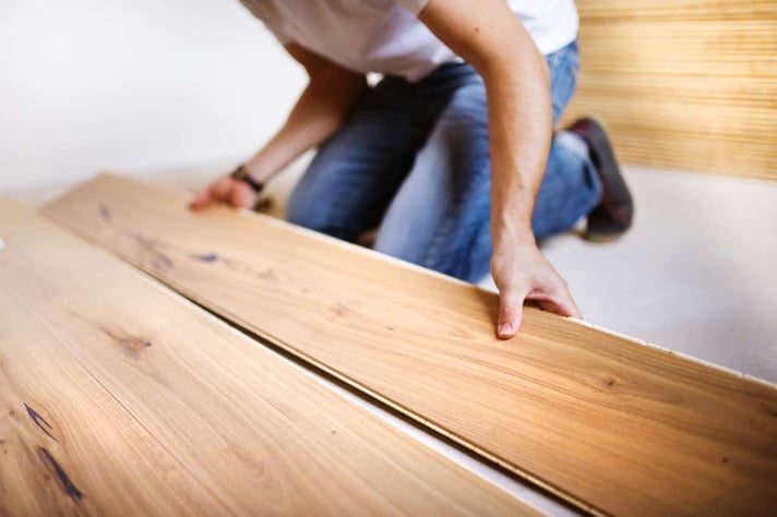 Handyman installing wooden floor (R) (S)