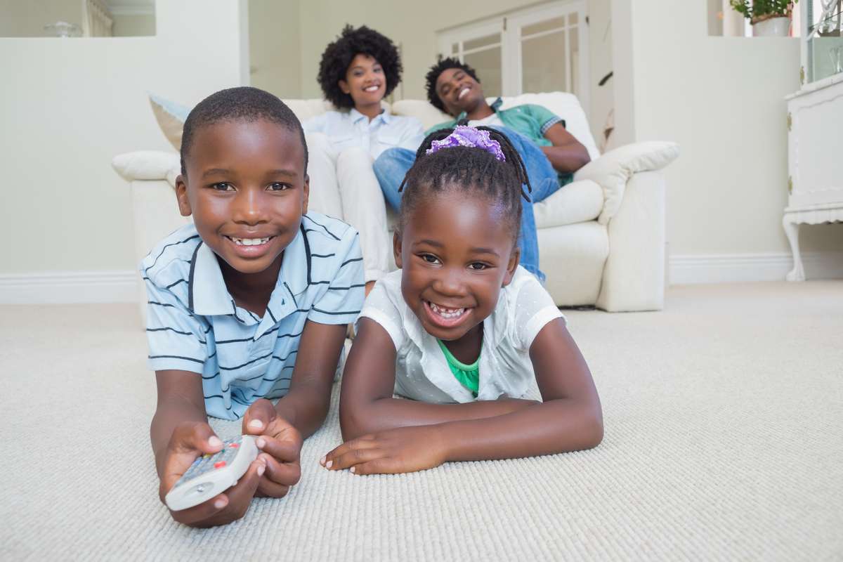Happy siblings lying on the floor watching tv (R) (S)