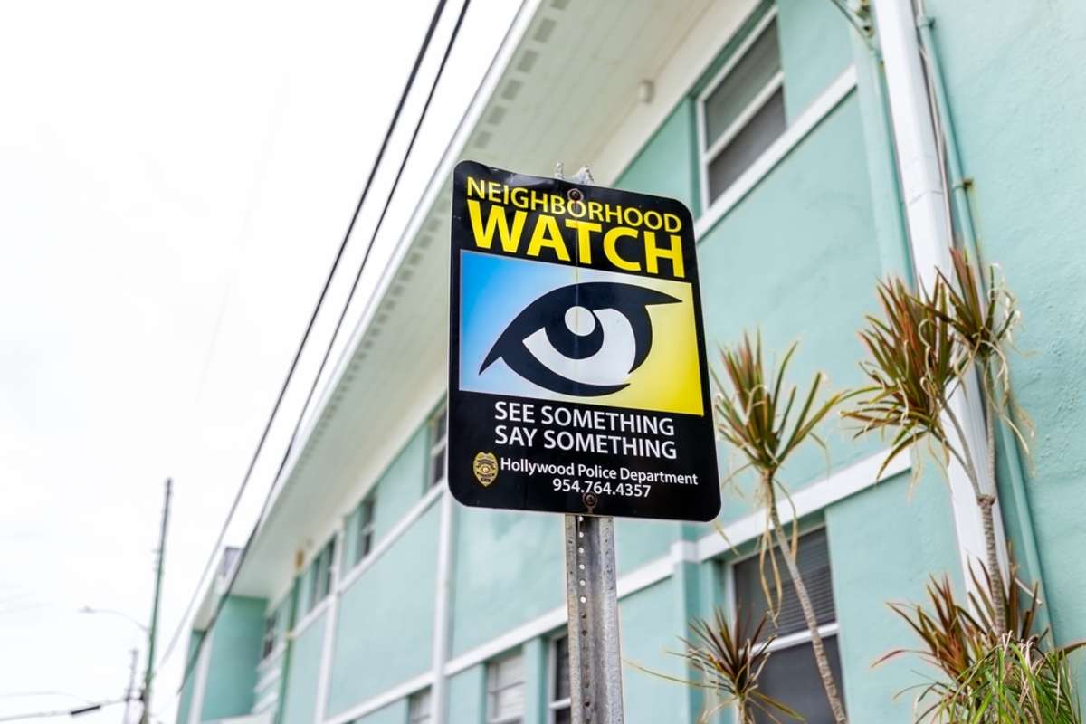 A Neighborhood Watch sign, crime impact on rental property ROI concept. 