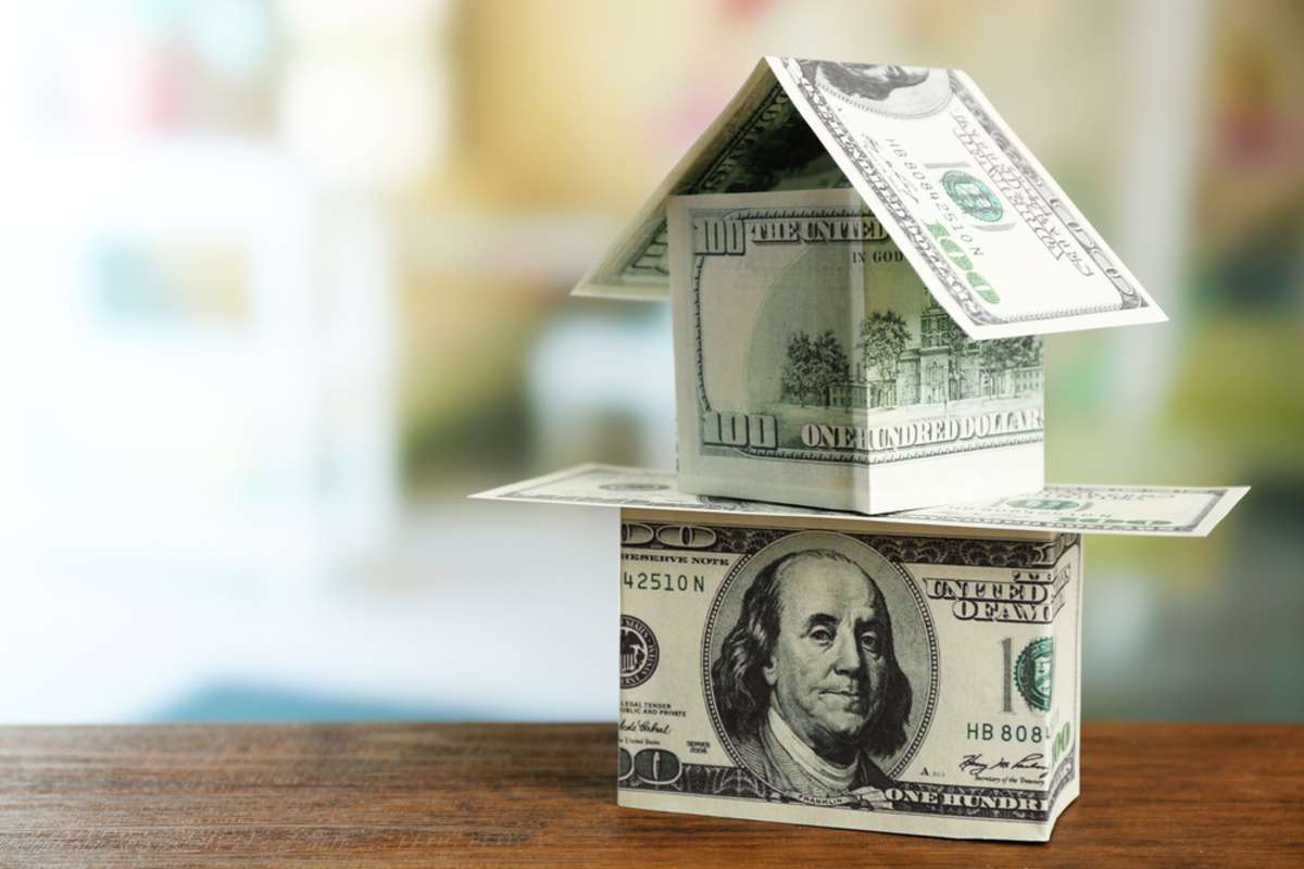 Money house on wooden table, close up