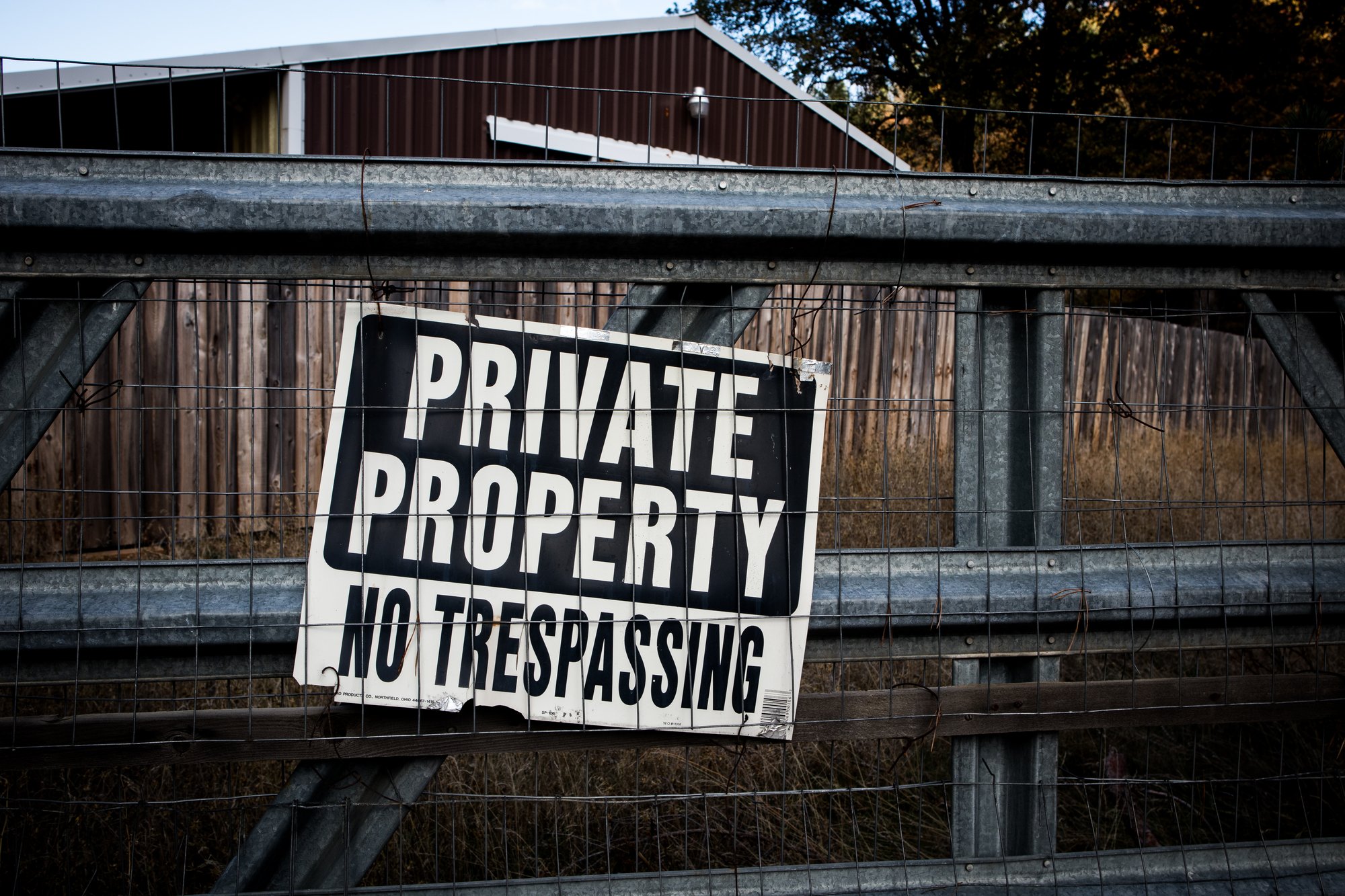 Sign on a fence that reads Private Property, No Trespassing