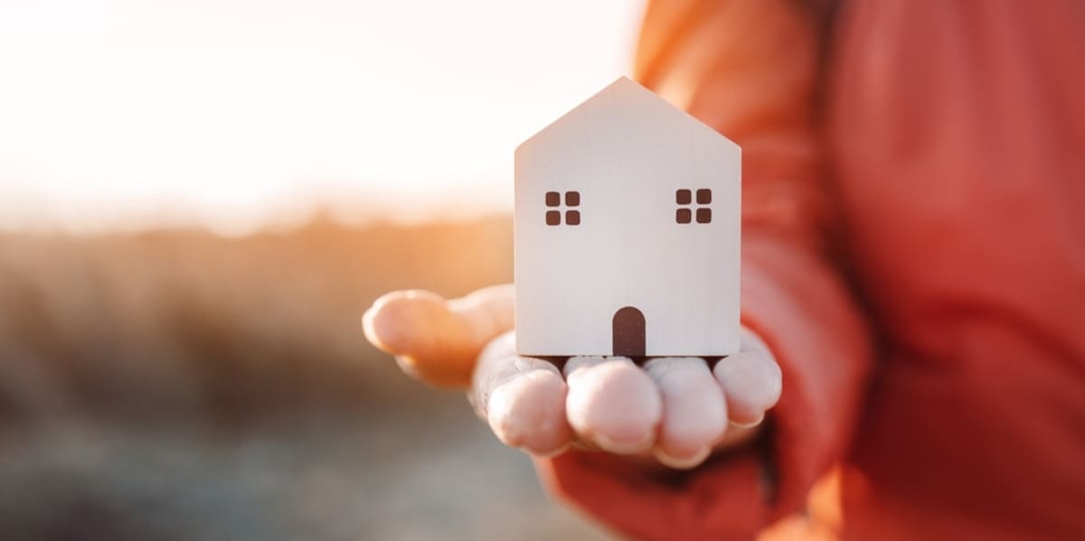 A man holds a small house in his hand, Delaware County property management concept