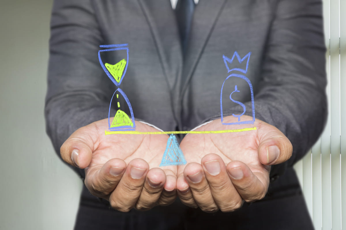 Businessman holding diagram with Scales in equal balance holding a clock left on the and money on the right
