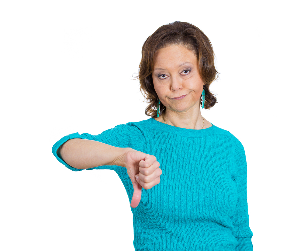 Closeup portrait of unhappy angry mad, pissed off senior mature woman, annoyed, giving thumbs down looking with negative facial expression disapproval, isolated white background. Emotion, sign, symbol