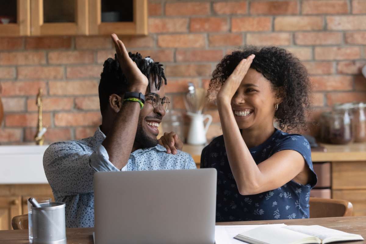 Happy couple celebrating success, how much can I rent my house for concept. 