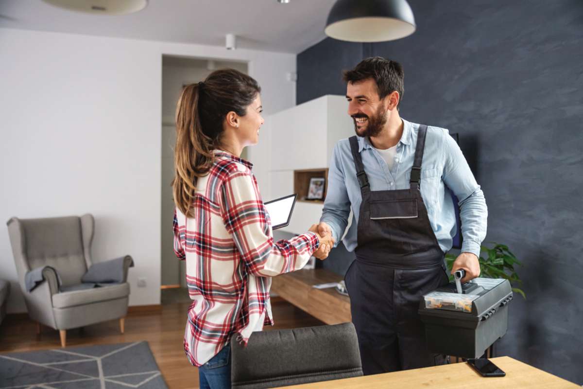 Happy woman shaking hands with repairman