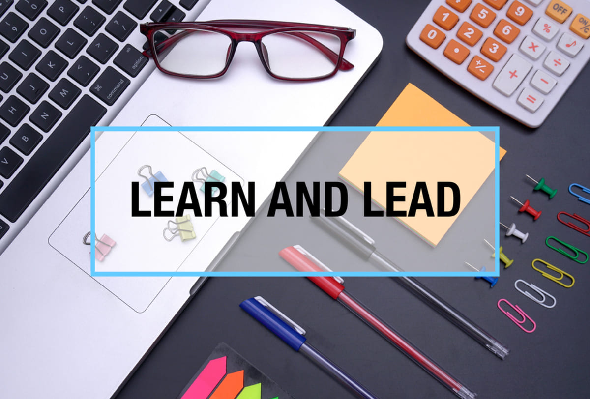 Learn and Lead over a laptop and desk items, Rentwell Property Management approach concept