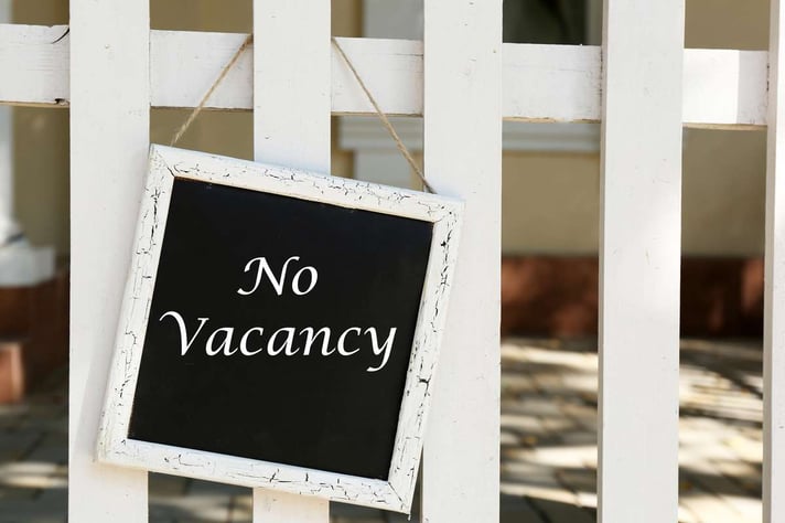 Signboard with text No Vacancy near hotel