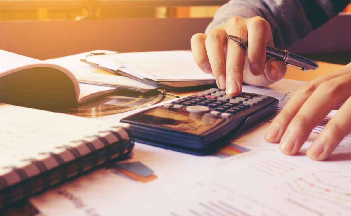 Woman using calculator with doing finance at home office.