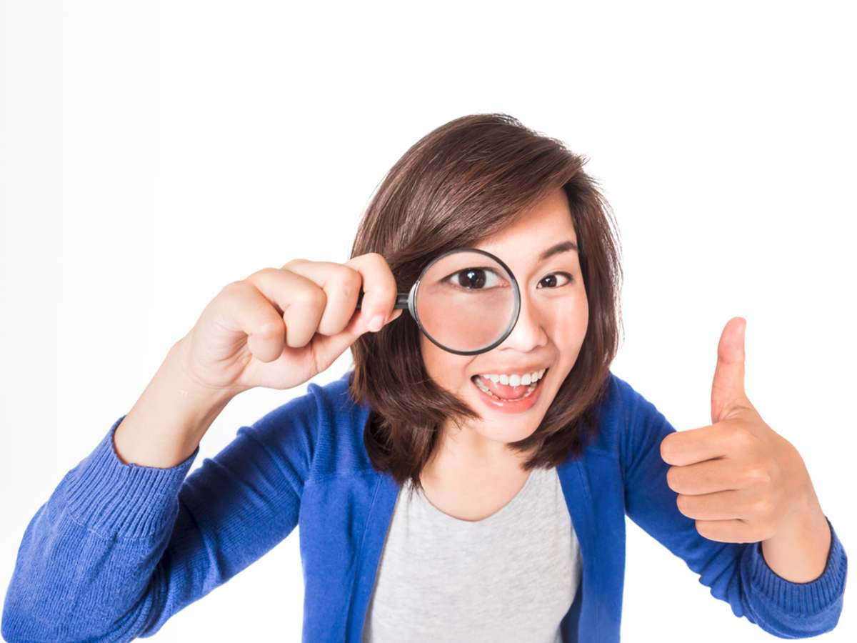 Young beautiful woman with magnifying glass