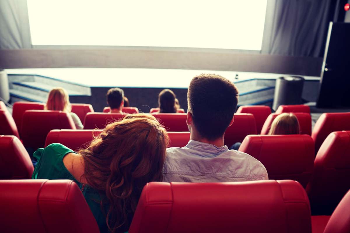 couple watching movie in theater from back