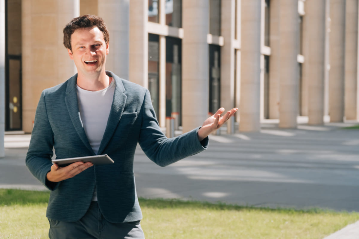 Residential real estate broker in front of a  multi-family building