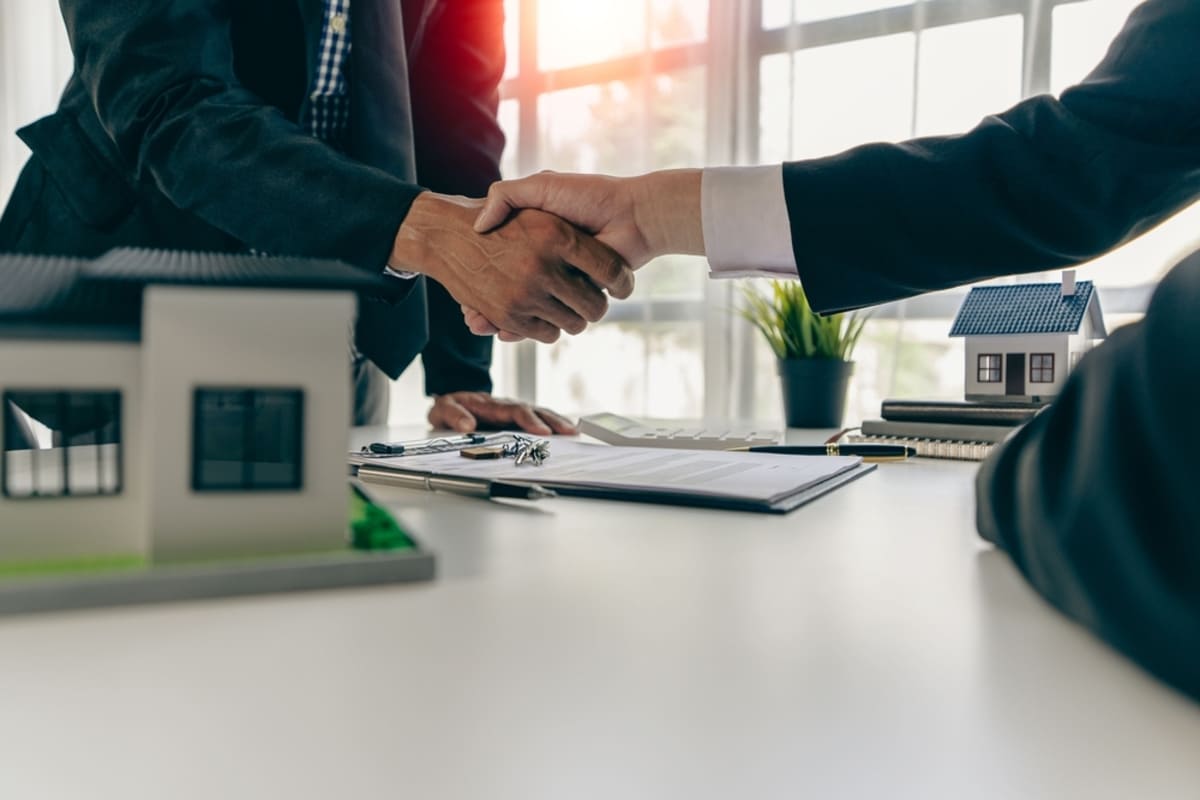 Successful management real estate agent shaking hands with client