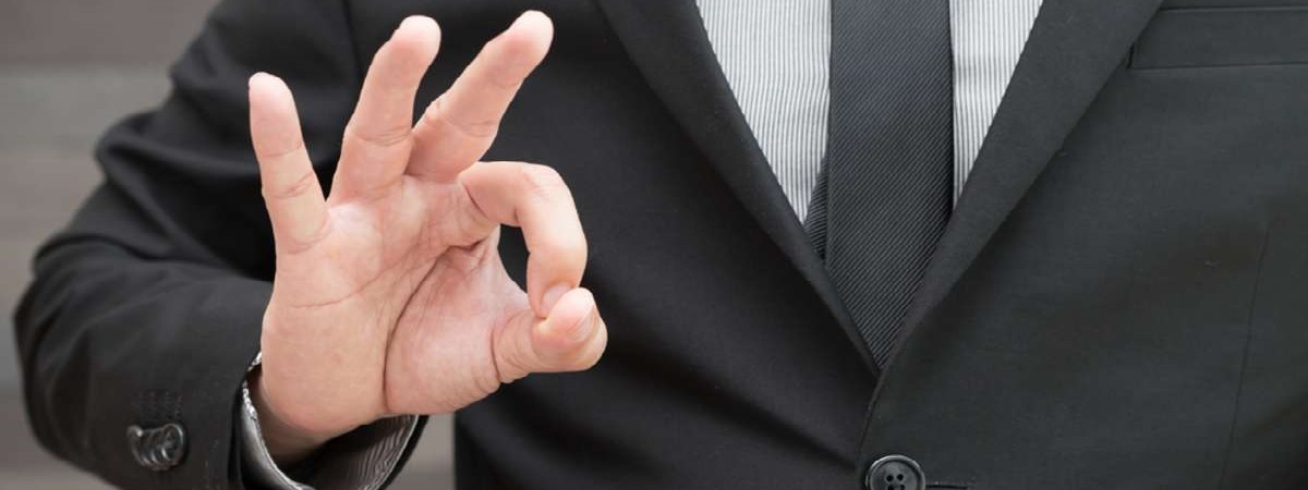 Businessman in suit and doing ok sign